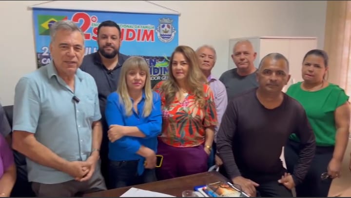 Lauredir Sandim (azul claro) um dos organizadores do evento, pai do vereador Gian Sandim proximo ao banner da festa