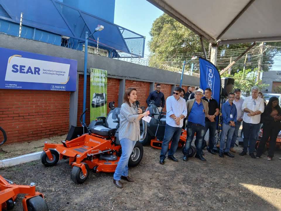 Agnaldo César, de camisa azul social e crachá, assessor e representante do vereador André Salineiro (PL), participa de evento ao lado da prefeita de Campo Grande, Adriane Lopes, e do secretário da SEAR, Darci Caldas, durante apresentação de novos equipamentos para reforçar os serviços de zeladoria na Capital.